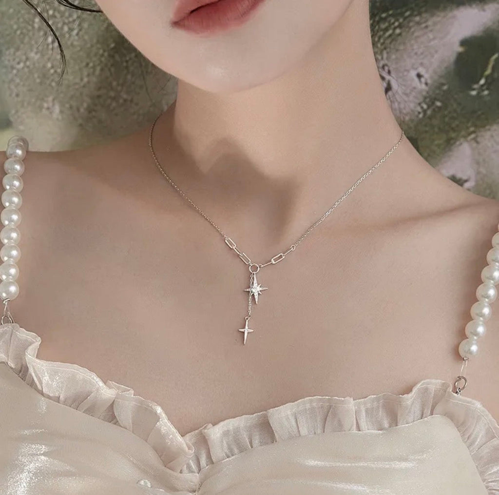 Dual north star lariat necklace product flat lay on white background