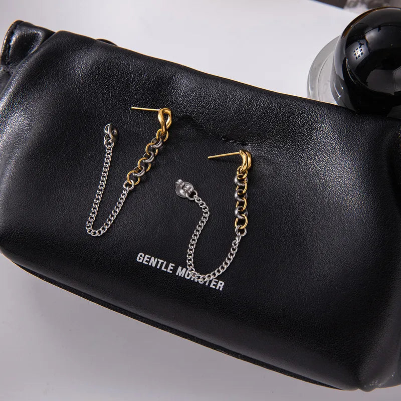 Two-tone chain drop earrings on marble surface lifestyle shot