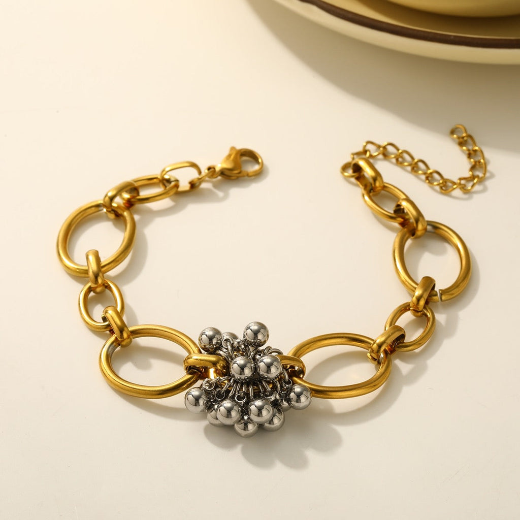 Gold chain beaded flower bracelet product shot on cream background