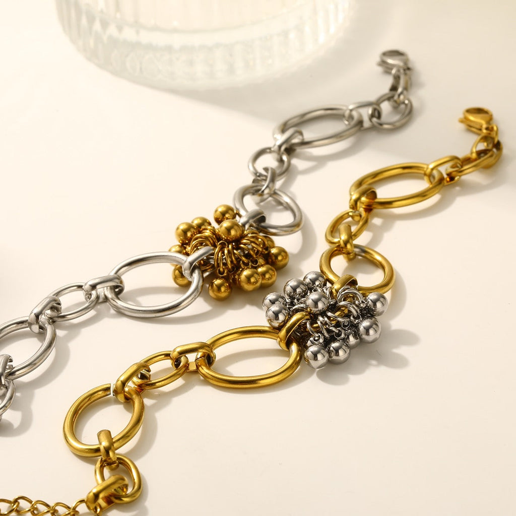 Two-tone beaded flower chain bracelets draped over ceramic cup