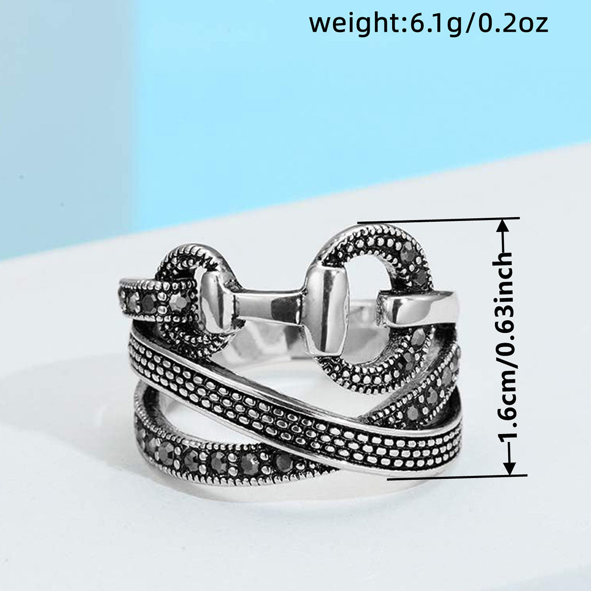 Oxidized silver CZ multi-band OT buckle ring worn on model hand with roses
