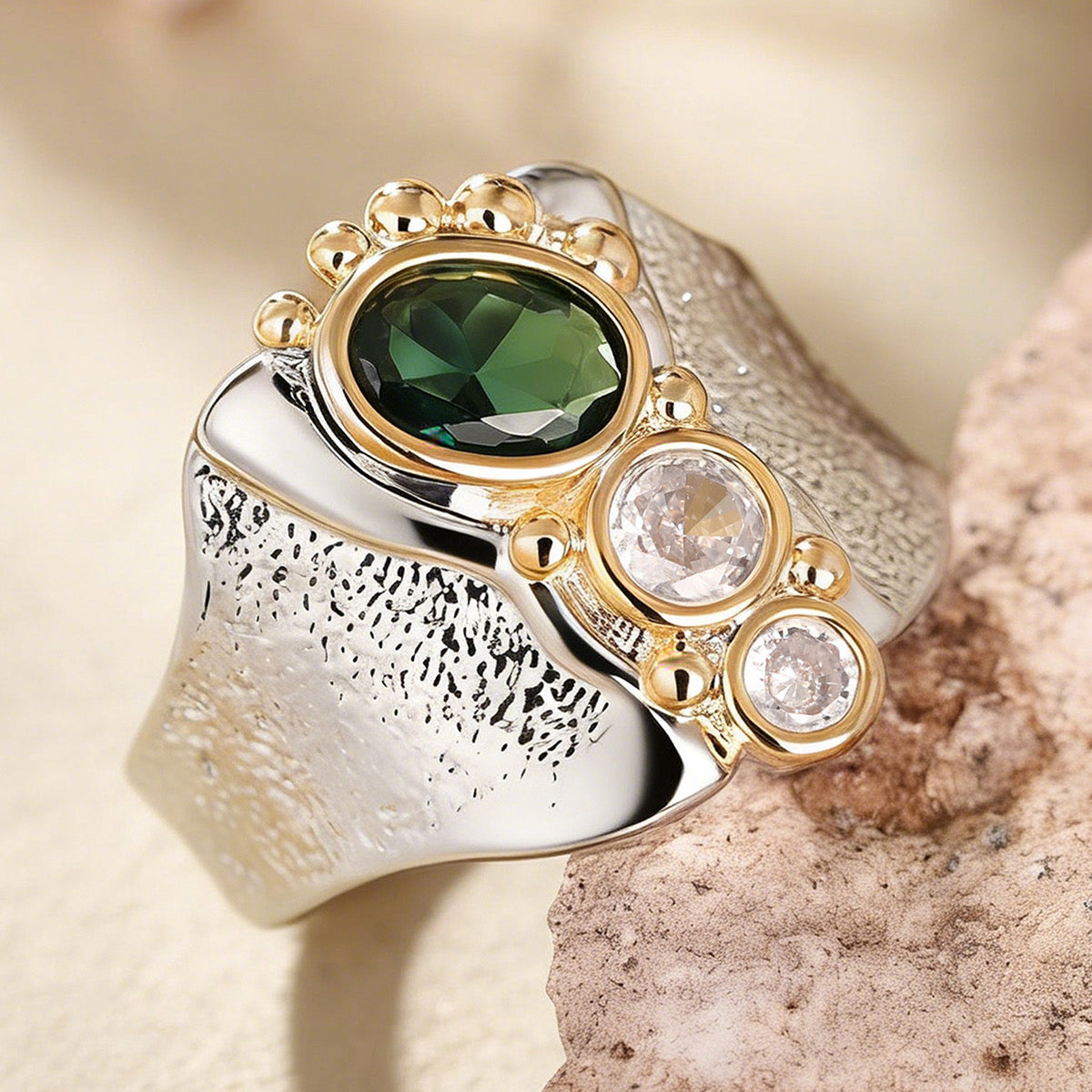 Emerald green stone wide-band ring on purple velvet